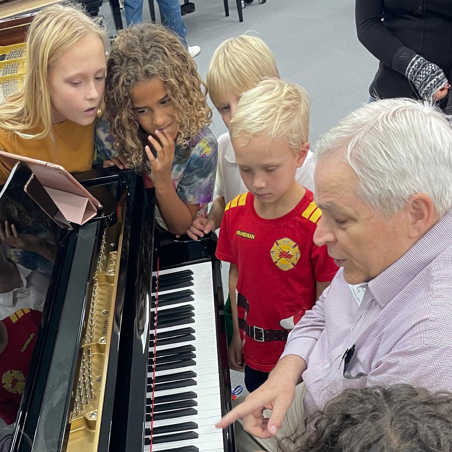 Piano techinician teaching young players the parts